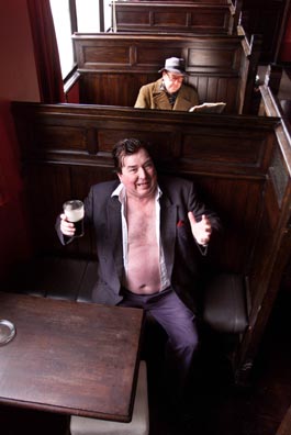 Photograph of Oliver Moore as Brendan Behan (front) with Ken McElroy as Patrick Kavanagh (behind), taken in a bar